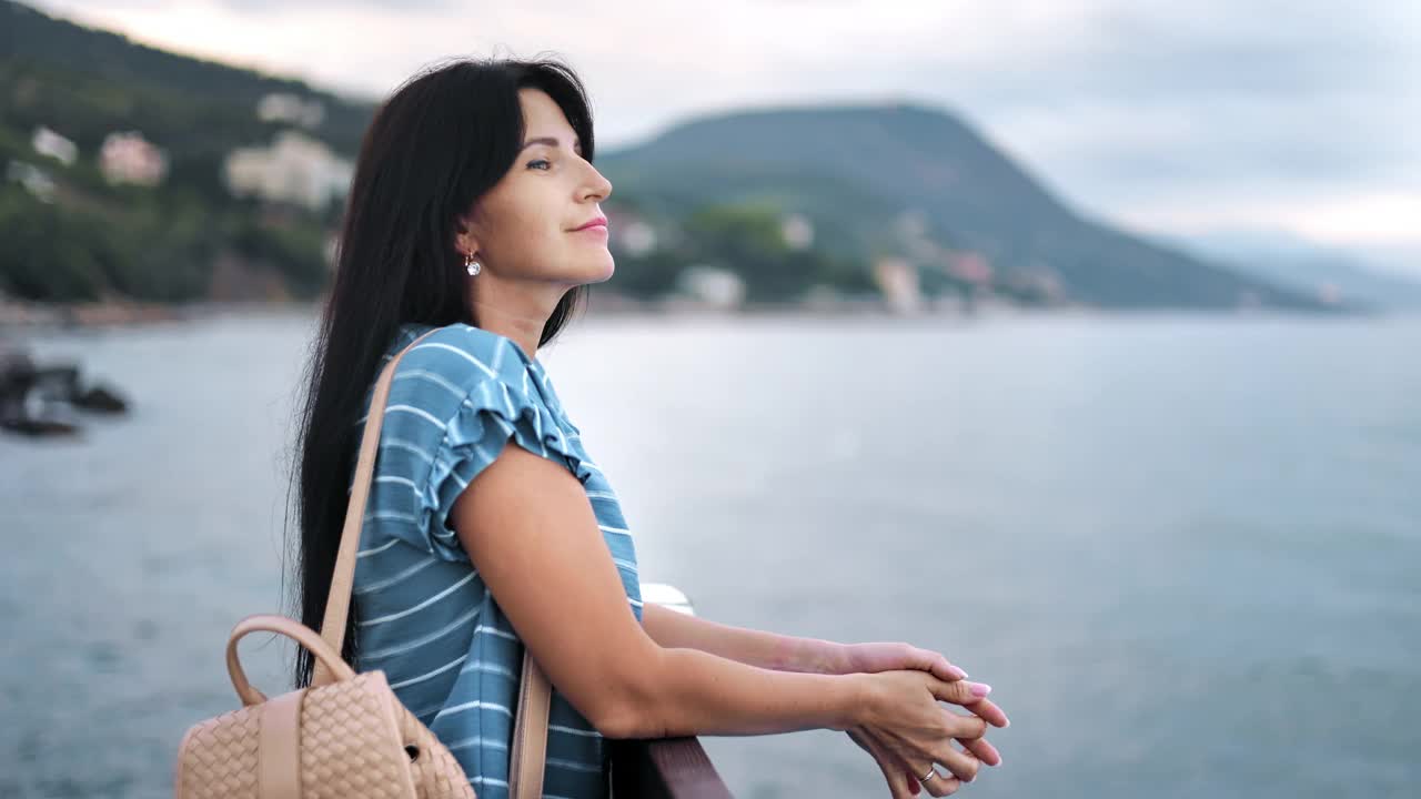 美丽的旅行女人放松地欣赏自然风景、海山、天空、地平线、暑假视频素材