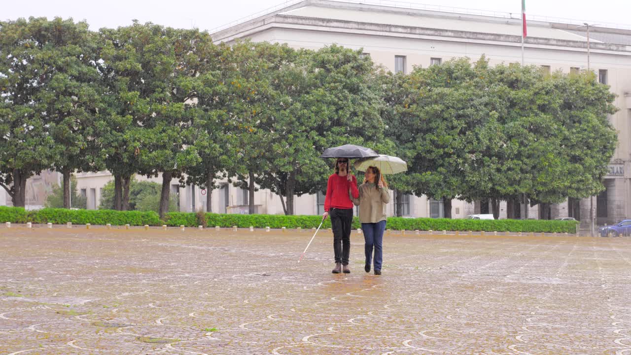 雨中漫步——一个盲人和他的朋友在雨天散步视频素材