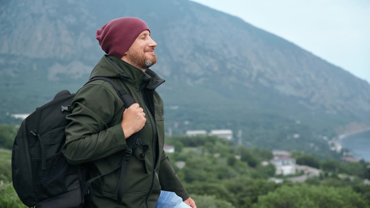 快乐的潮男旅行者欣赏自然的海景从山顶享受冒险假期视频素材