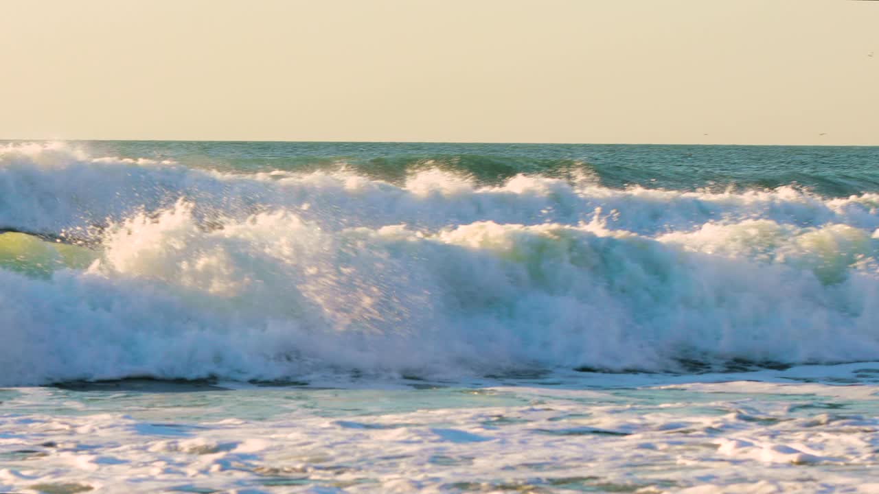 海浪拍打着沙滩。海滩上的日出。视频素材