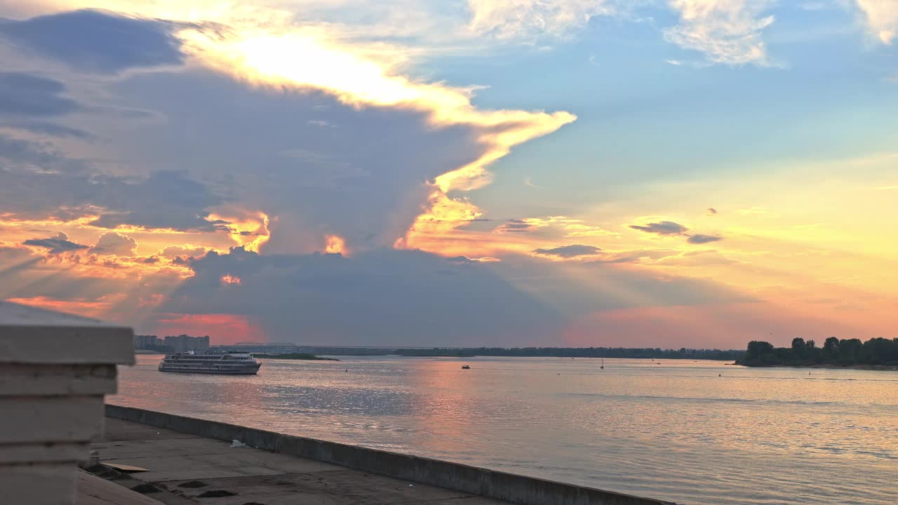 游船沿伏尔加河和奥卡河汇合处行驶的全景。现代海上运输的背景与多彩的日落，云和阳光，下诺夫哥罗德，俄罗斯视频素材