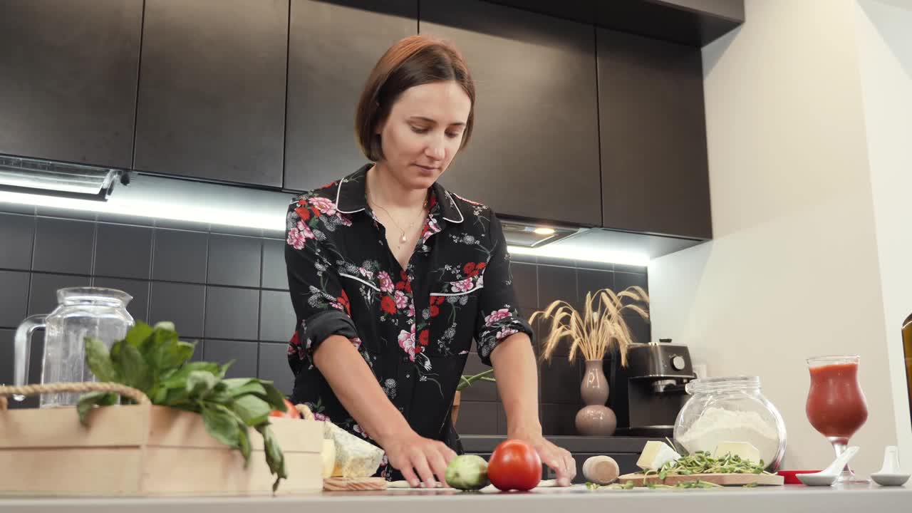 做披萨。年轻女子的肖像烹饪自制披萨在家里的厨房。女用擀面杖擀面。制作传统玛格丽塔披萨的过程。健康饮食视频素材