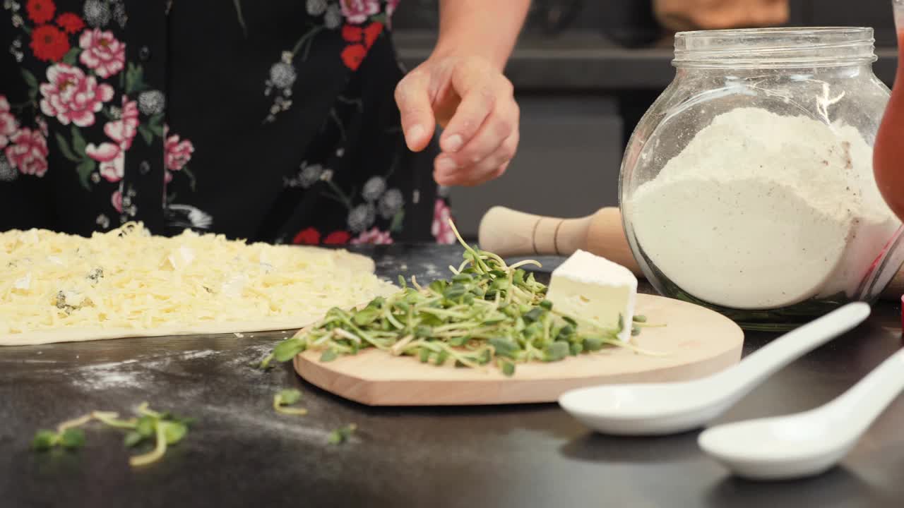 女人在家里的厨房。在家厨房做饭的女性。家庭主妇在家做饭。披萨的制作过程视频素材