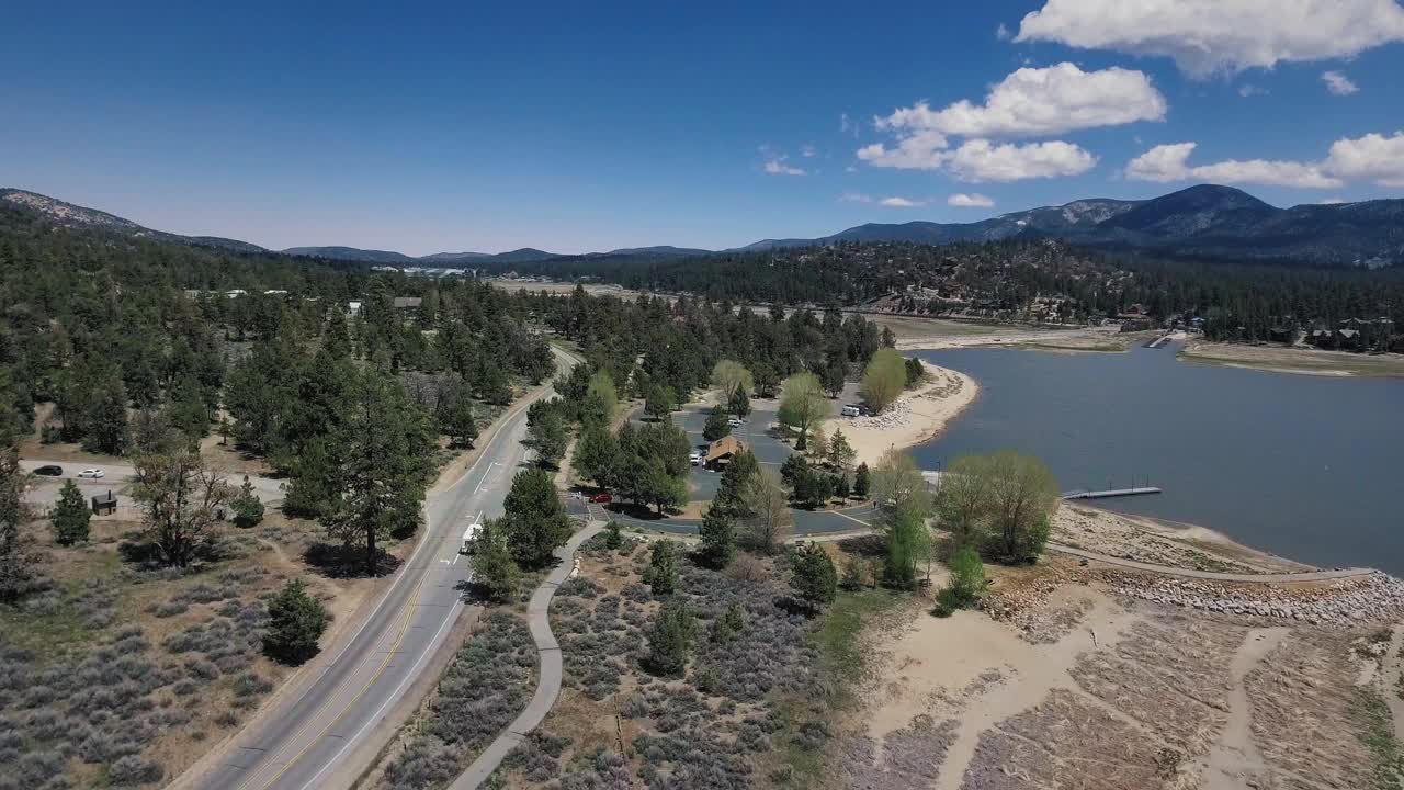 鸟瞰一辆白色拖车沿着大湖和大熊太阳观测站附近的道路行驶，大熊湖鸟瞰图，加利福尼亚，美国视频素材