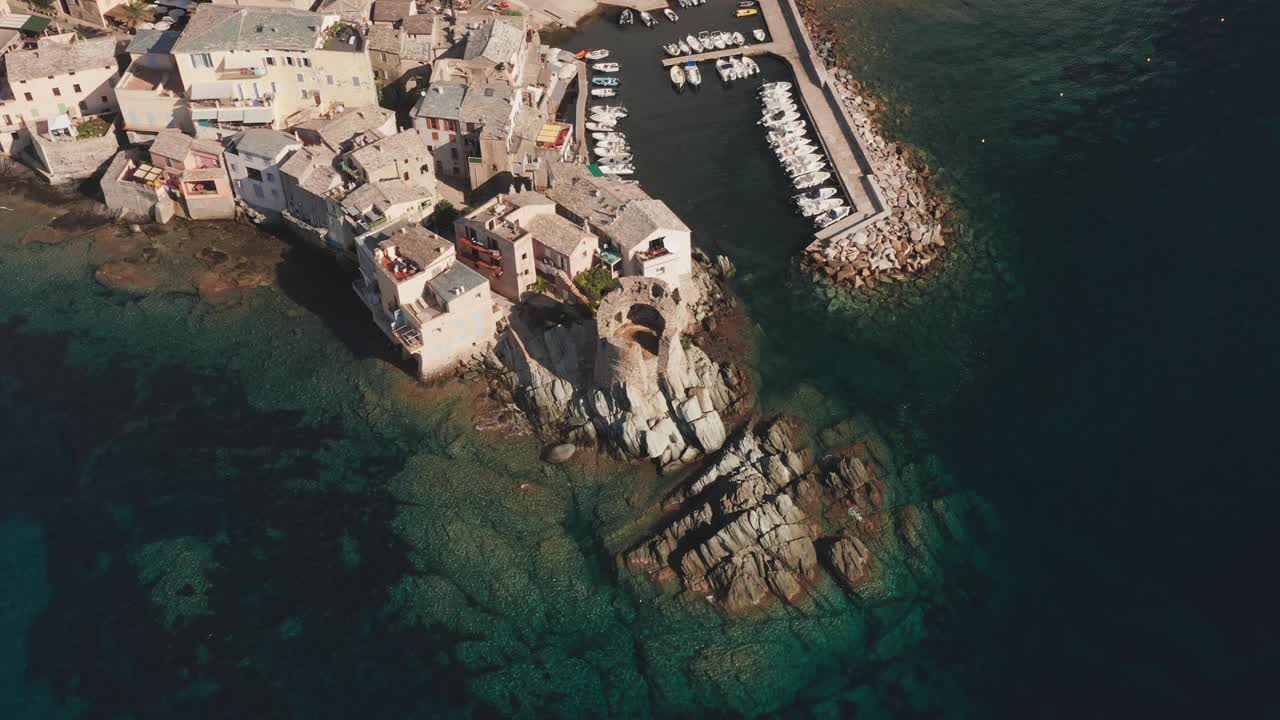 科西嘉岛特色石村港口鸟瞰图。生动的蓝色的大海。鸟瞰图的海岸，美丽的大海，房屋，树木在阳光明媚的夏日。视频素材