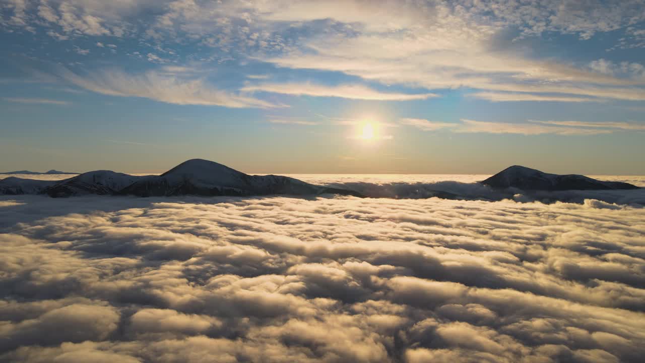 鸟瞰生机勃勃的日出在白色的浓雾与遥远的喀尔巴阡山脉的黑暗山峰在地平线上。视频素材