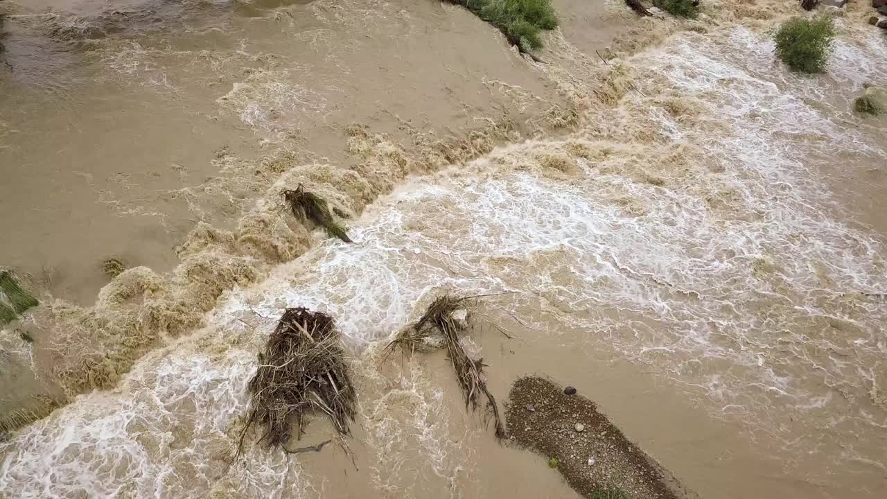 鸟瞰图宽阔的肮脏的河流与泥泞的水在洪水期间在暴雨的春天。视频素材