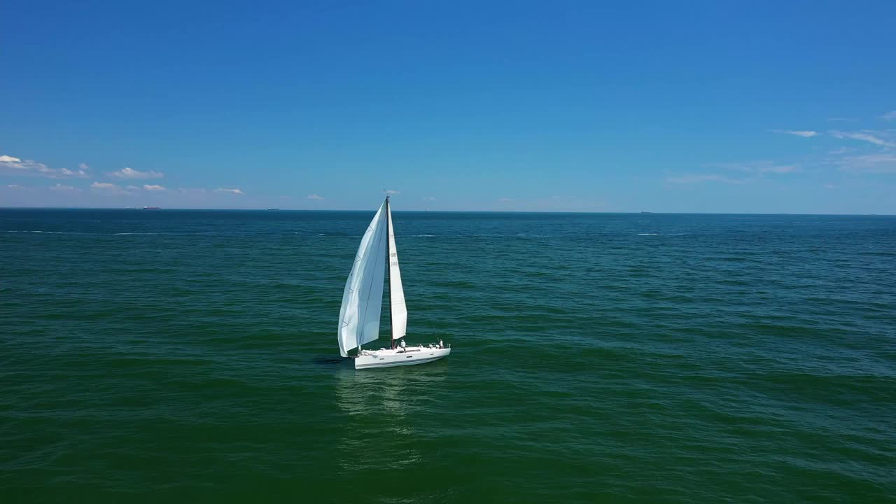 日落时小游艇在平静的海面上航行的低角度海平面视图视频素材