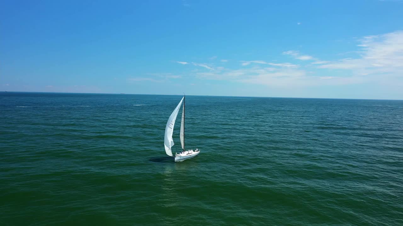 日落时小游艇在平静的海面上航行的低角度海平面视图视频素材