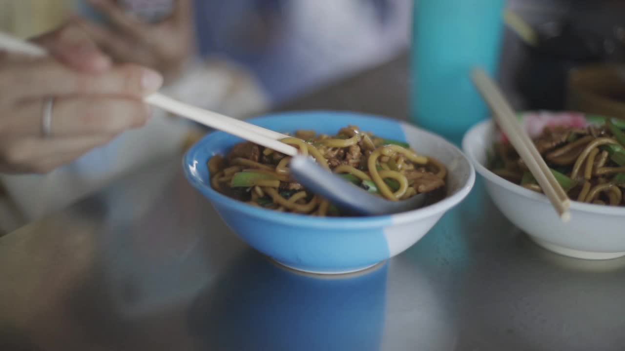 年轻妇女在餐馆吃街头小吃面食视频素材