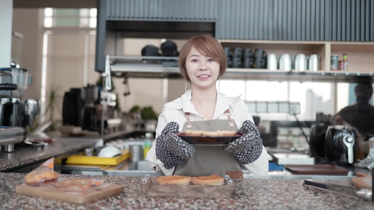 身穿围裙的亚洲华人企业家们一边准备食物一边看着镜头视频素材