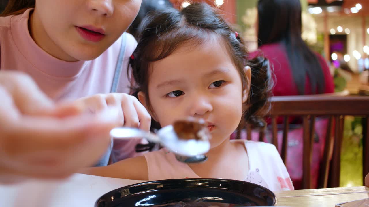 小女孩喜欢和妈妈在餐厅吃饭。视频素材