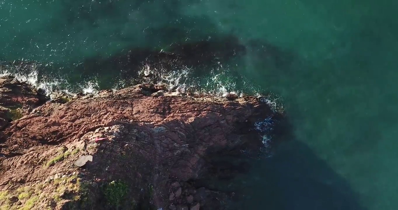 鸟瞰图海浪打破岩石在蓝色的海洋。视频素材