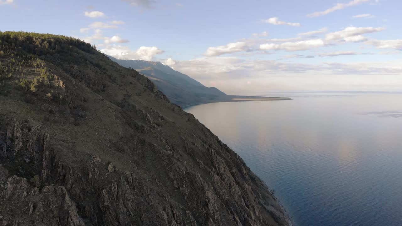 美丽的贝加尔湖岸边碧蓝的湖水。空中无人机视图。俄罗斯西伯利亚的贝加尔湖。美丽的春天风景视频素材