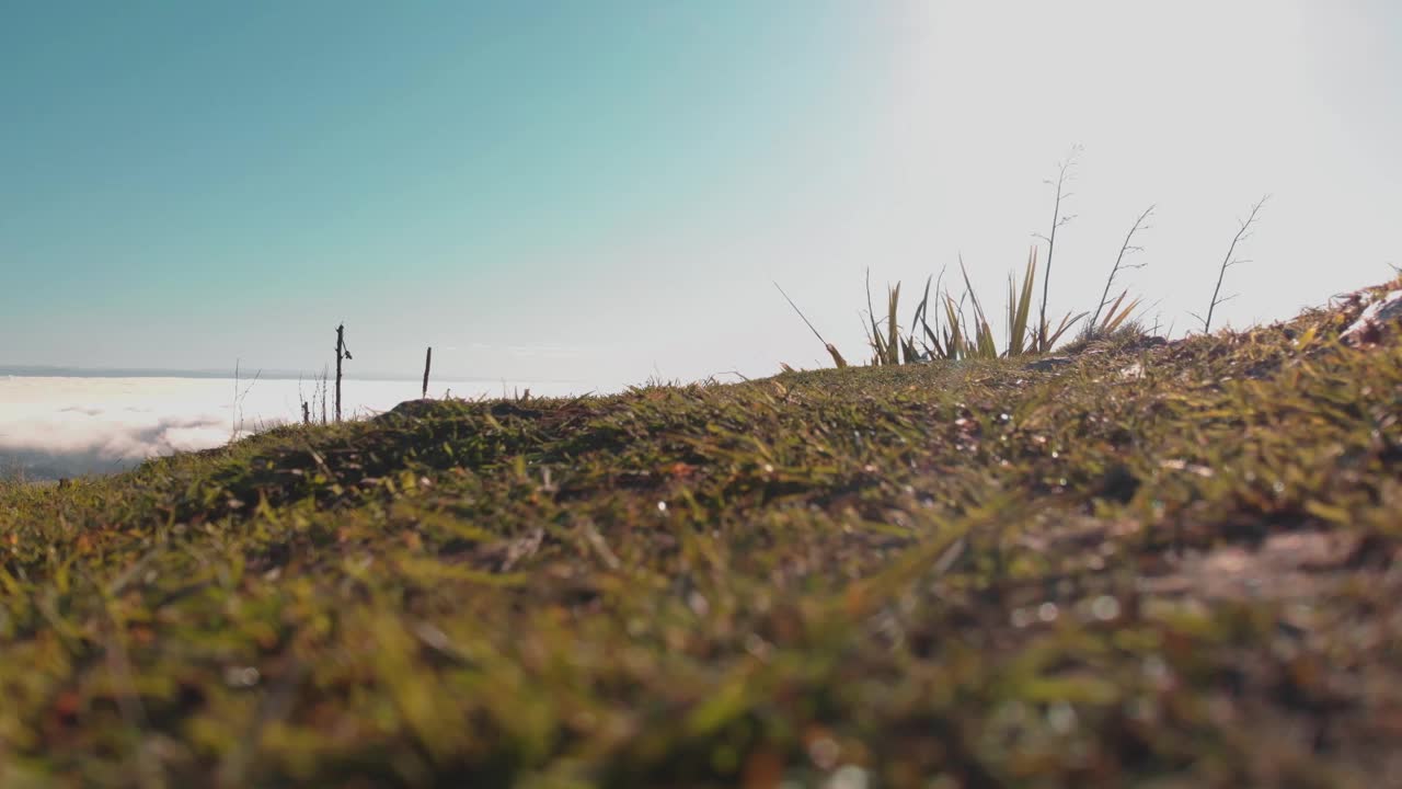 一个人在山顶上走向摄像机。从地上拍的视频素材