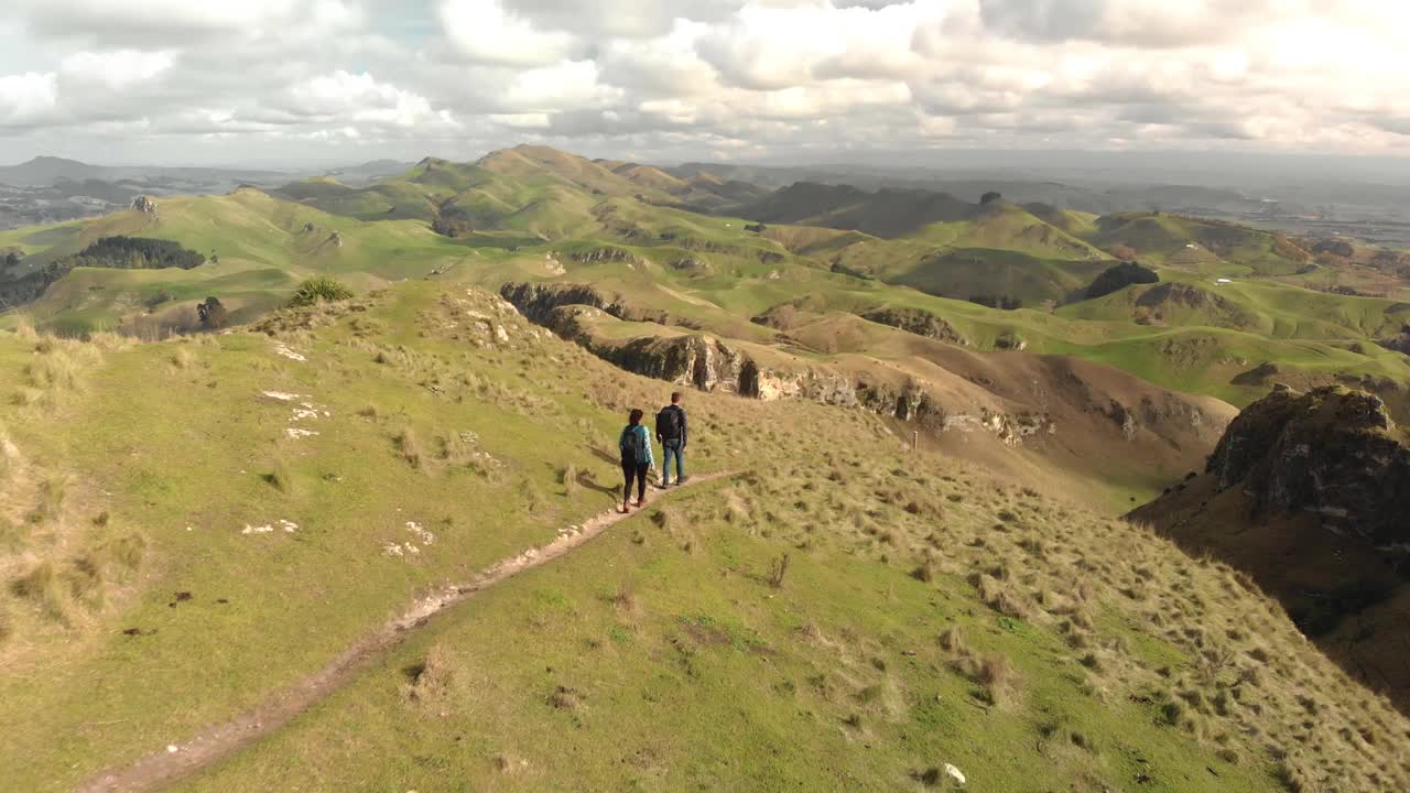 一对徒步旅行者走在令人惊叹的山景边缘视频素材