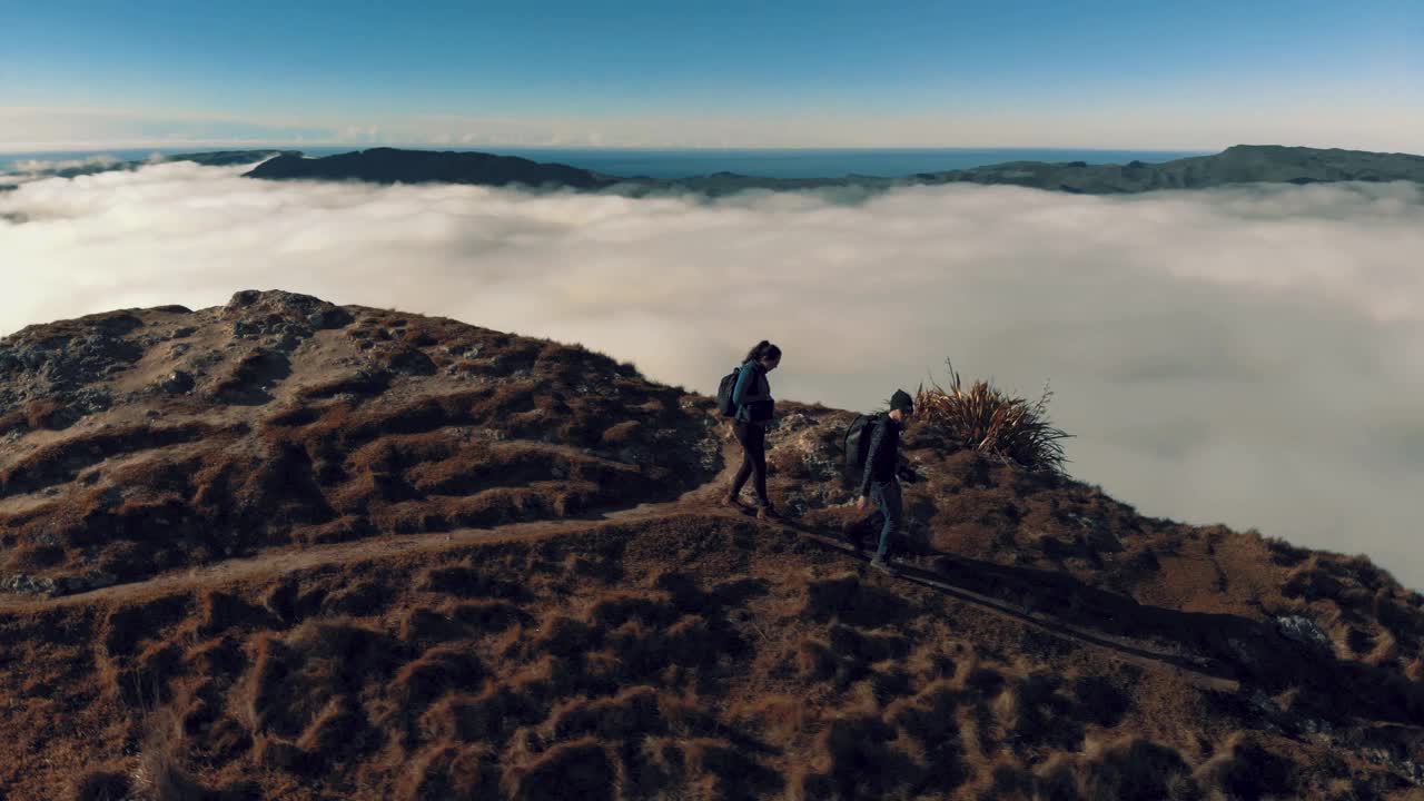 一对夫妇在云雾缭绕的山顶上徒步旅行视频素材