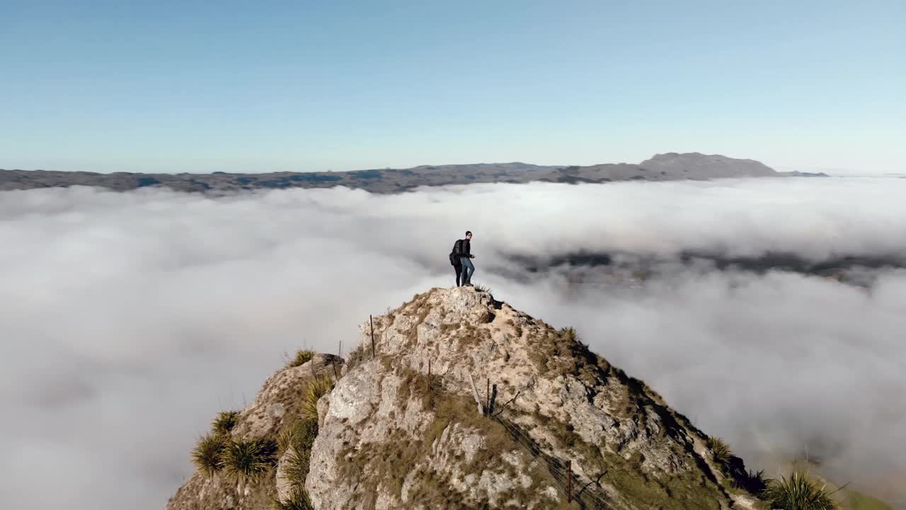 雄伟的圆形鸟瞰图，一对夫妇站在山顶。多云的景观视频素材