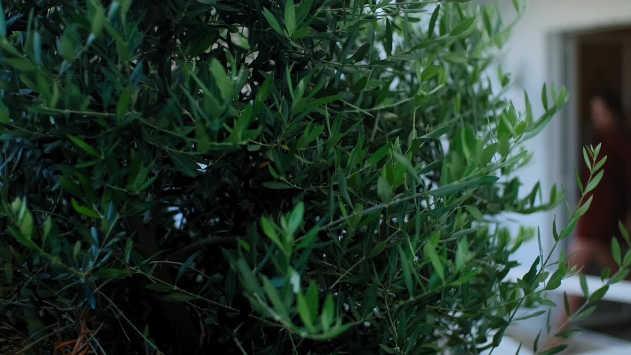 女人走到阳台，靠在栏杆上，从阳台上欣赏风景。Rbbro年轻女性穿连衣裙视频素材