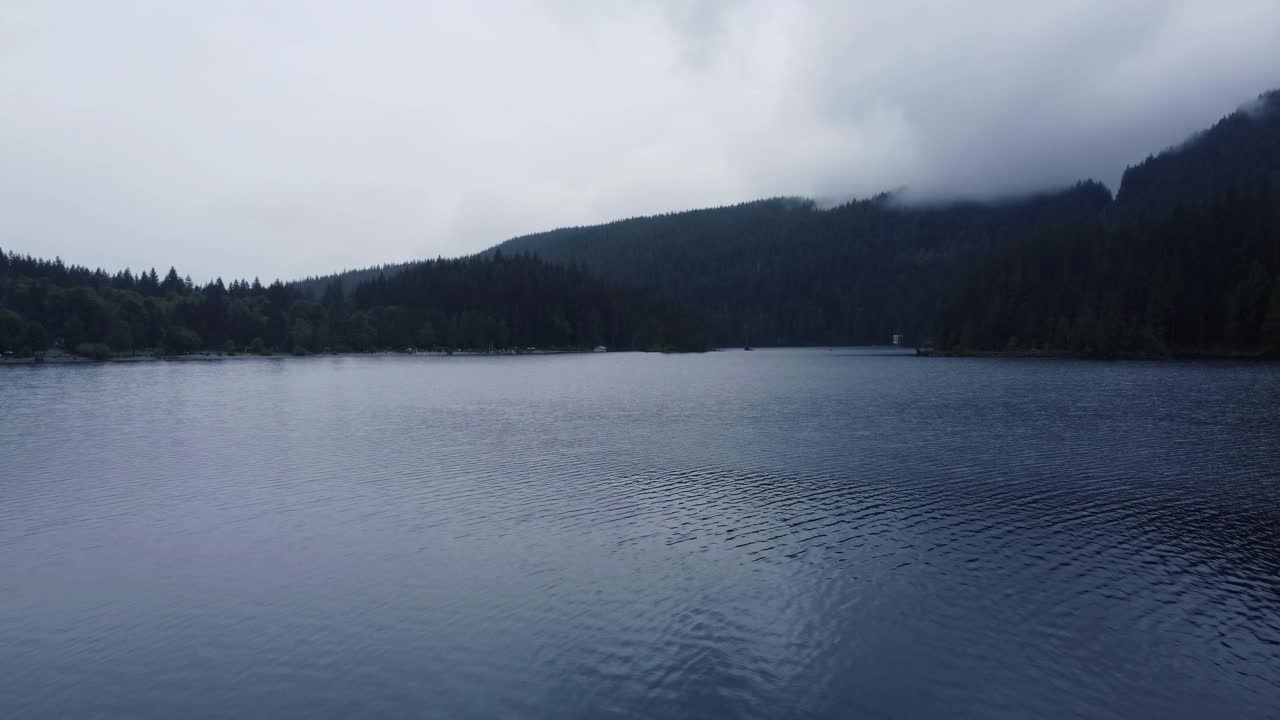 在加拿大的一个多云的日子，飞越被绿色山脉环绕的湖泊视频素材
