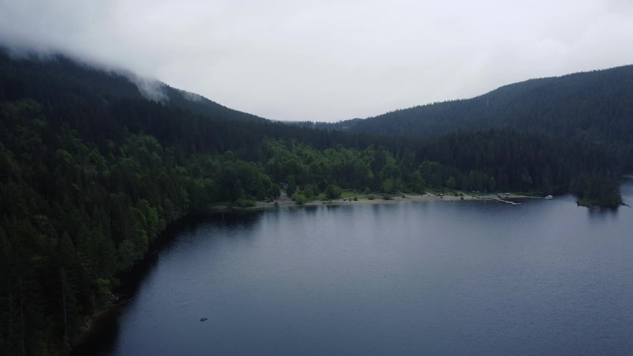 雨天在加拿大公园，周围有湖和绿色的森林小山视频素材