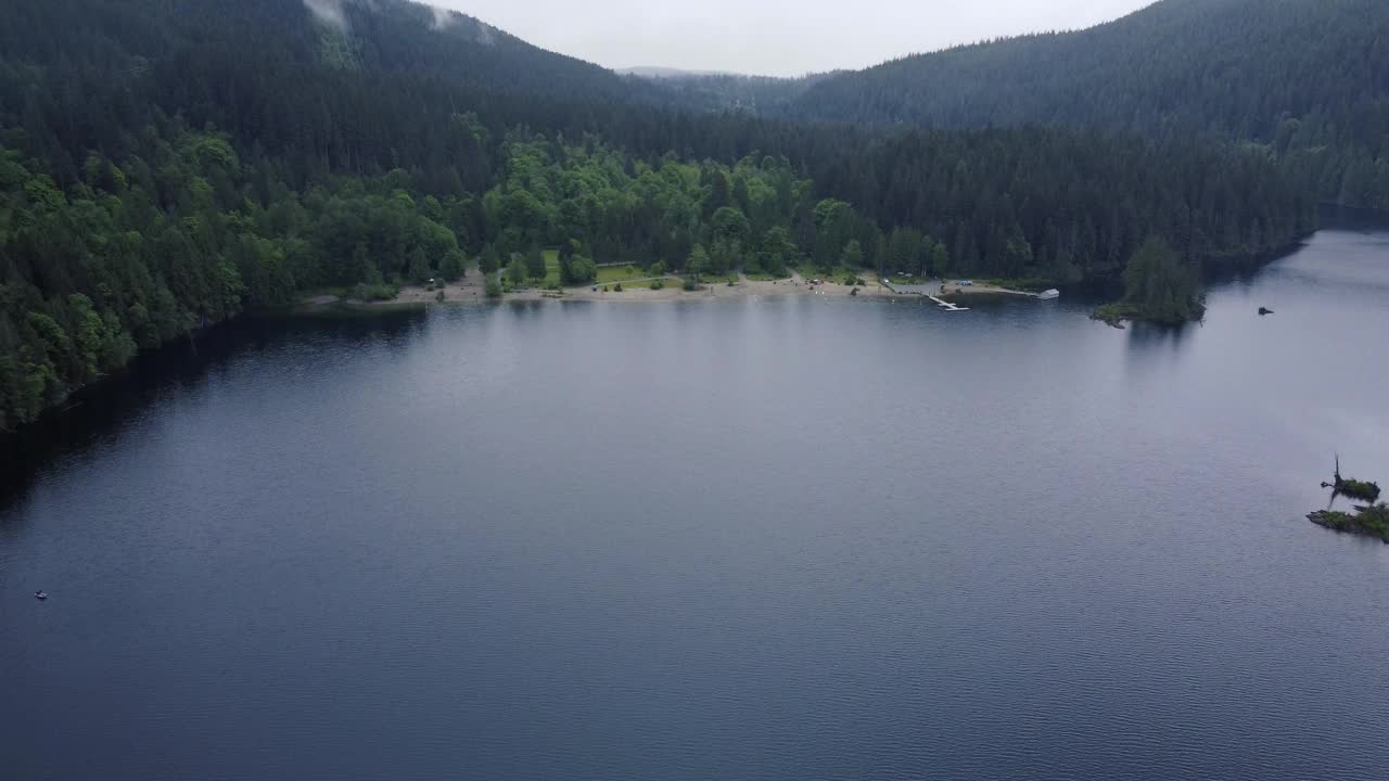 鸟瞰图的空海滩附近的湖与云杉山在一个雨天视频素材