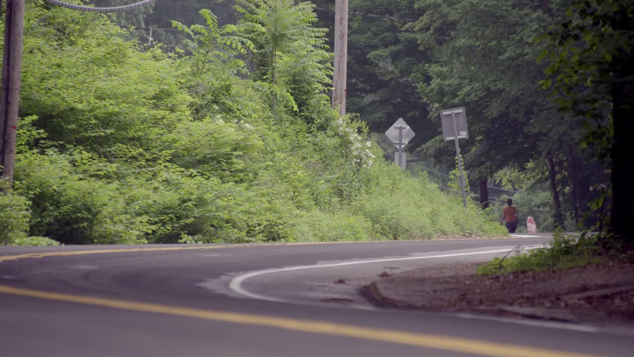 中等角度的乡村道路两旁有电线杆和树木。从bg开车到fg。视频素材