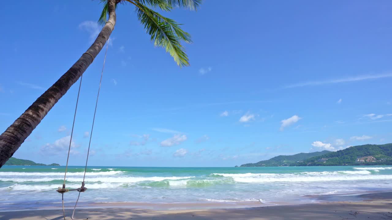 阳光明媚的夏日大海，美丽的热带海滩巴东海滩风景，美丽的泰国普吉岛，椰子树海浪拍打沙滩，令人惊叹的旅游和旅游背景视频素材