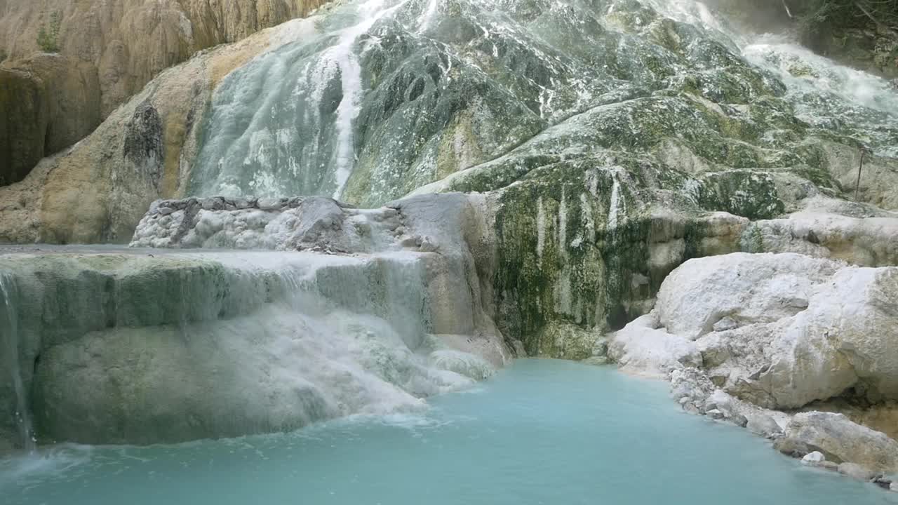 慢镜头:意大利托斯卡纳的地热池和温泉。巴格尼圣菲利波天然热瀑布在早上没有人。森林中的白鲸。视频素材