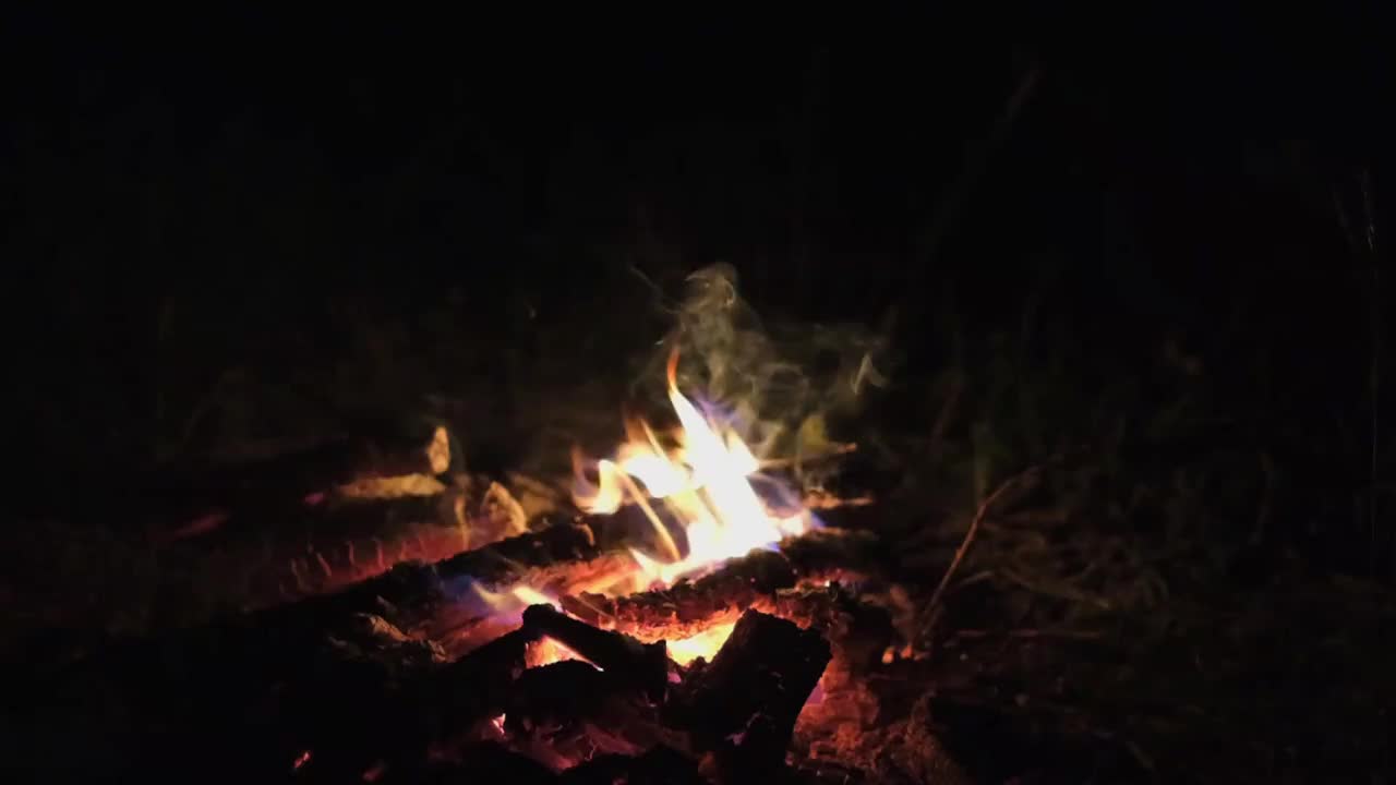 夜晚篝火特写，木头在燃烧，火焰和火花在飞舞，慢镜头。视频素材