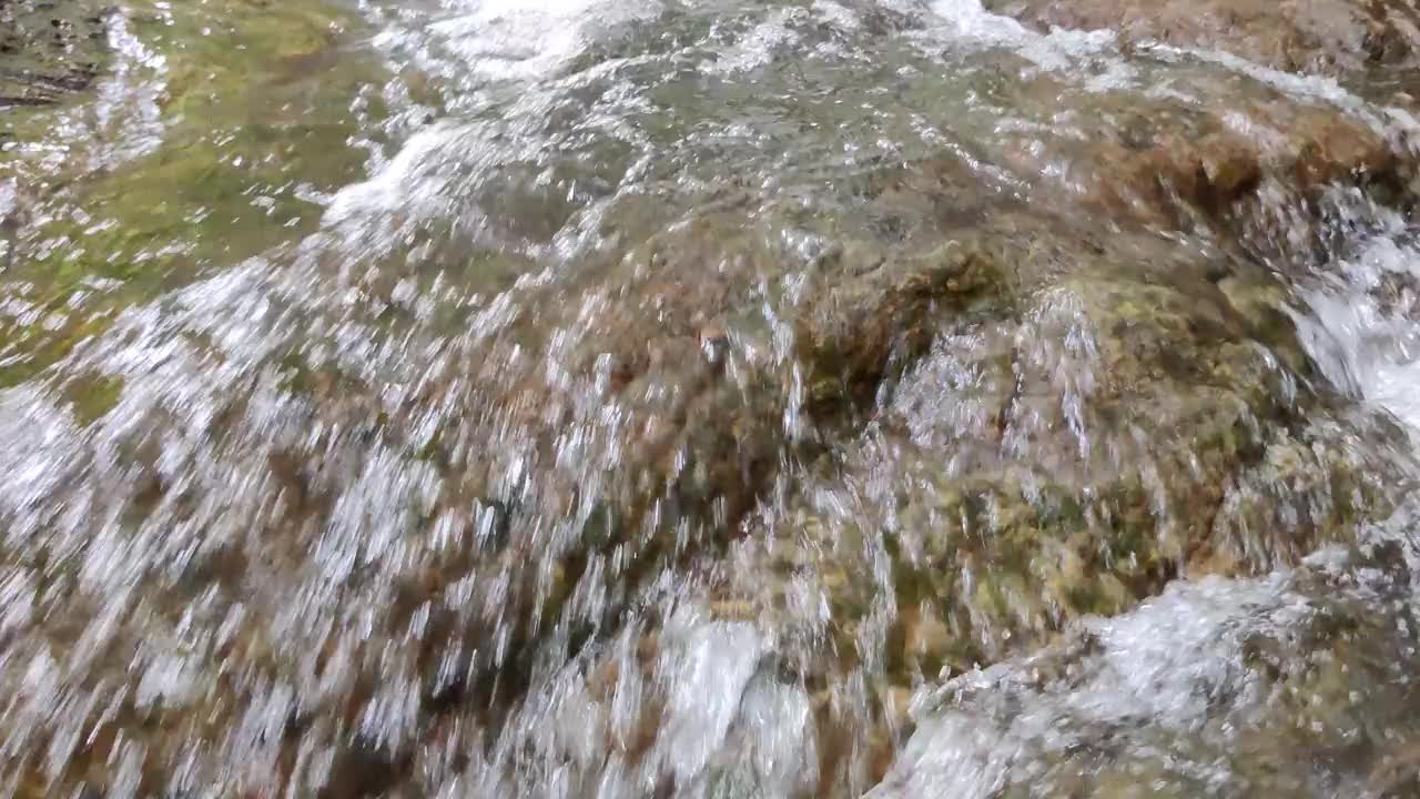 在湍急的溪流中，水从岩石和石头上流下来视频素材