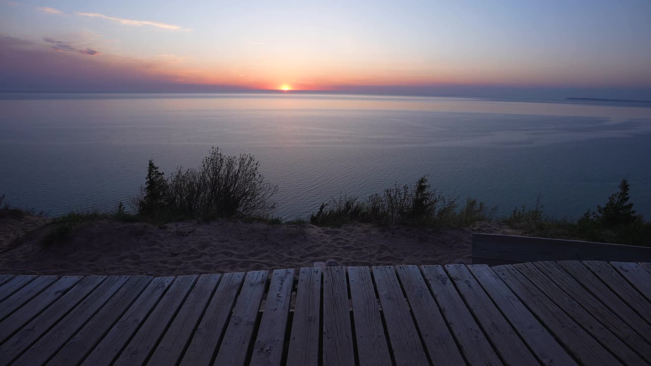 夕阳在地平线上的密歇根湖和人行道视频素材