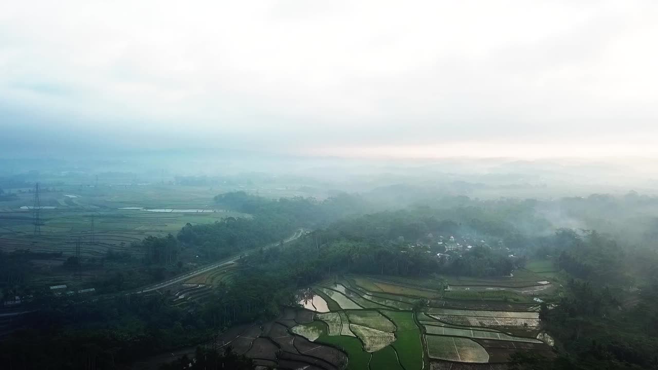 雾蒙蒙的日出时，印尼乡村风景的航拍视频素材