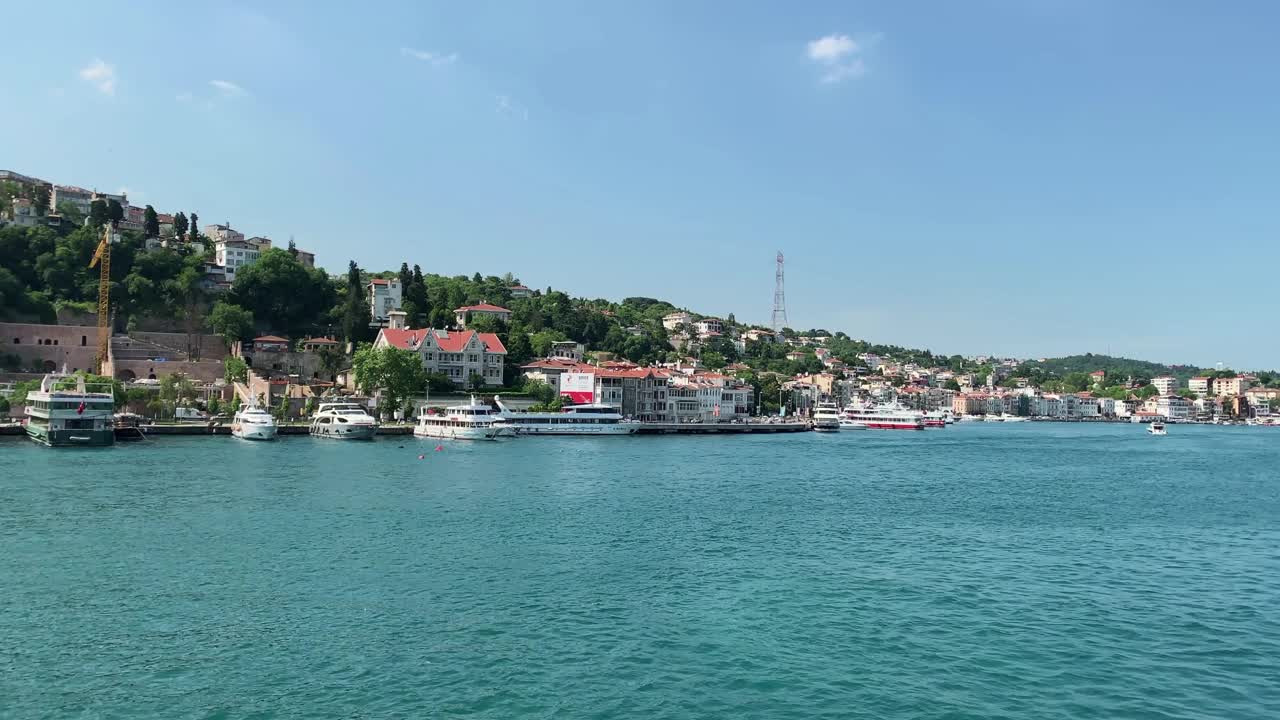 在伊斯坦布尔被称为“Kurucesme”和“Arnavutkoy”的高档社区，停泊着游艇和船只的视频。这是阳光灿烂的夏日里博斯普鲁斯海峡的美丽景色。视频素材