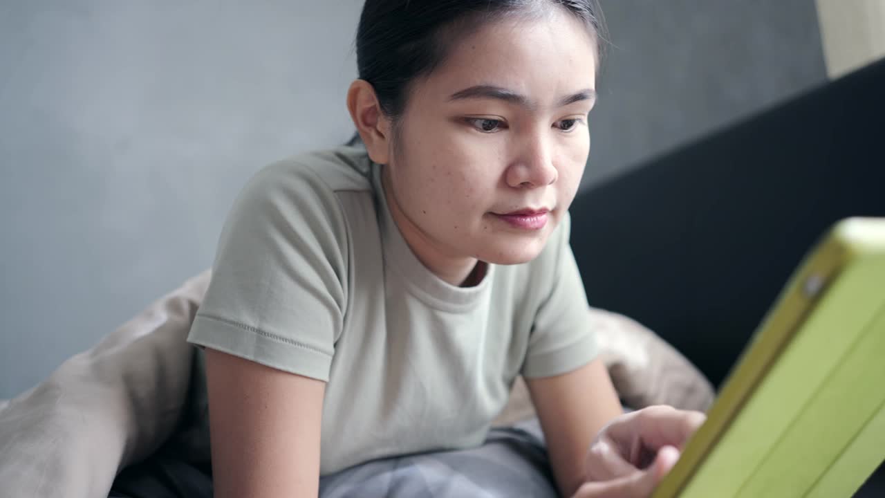 一个女人早上在床上玩社交媒体视频素材