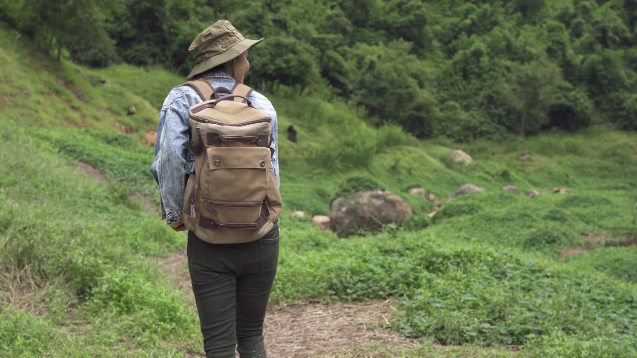 4K亚洲女性背包客在小溪边的山路上徒步旅行视频素材