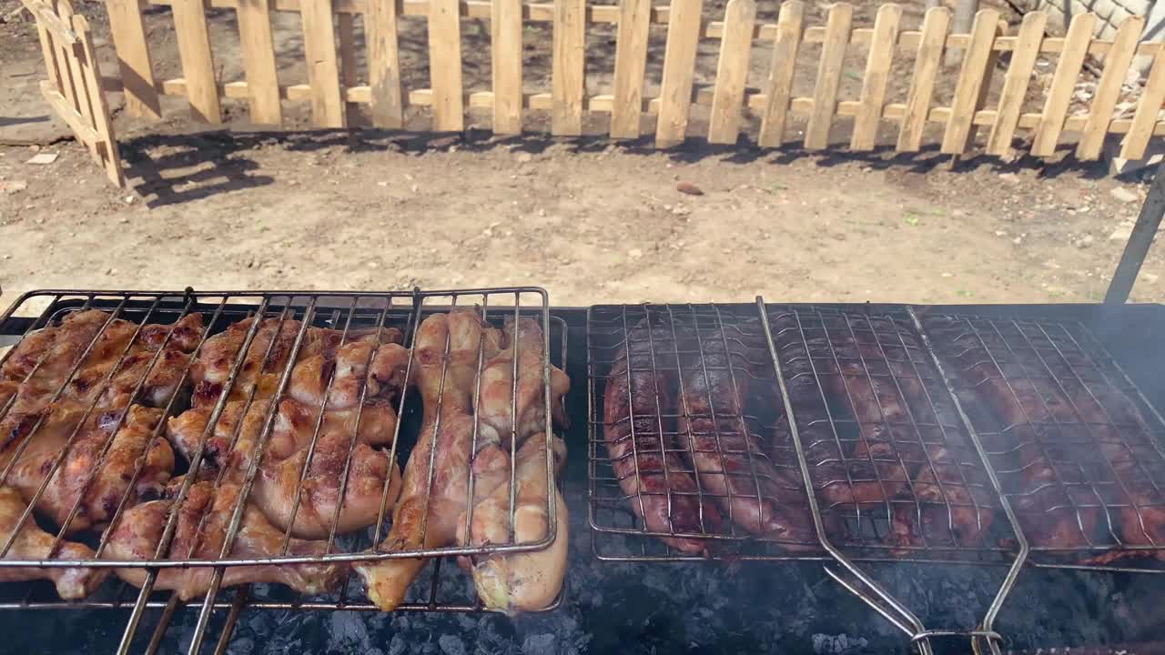 在院子里私人住宅的烤架上，烤鸡和猪肉香肠正在煮着，可以看到烧烤时发出的令人愉快的烟味。视频素材