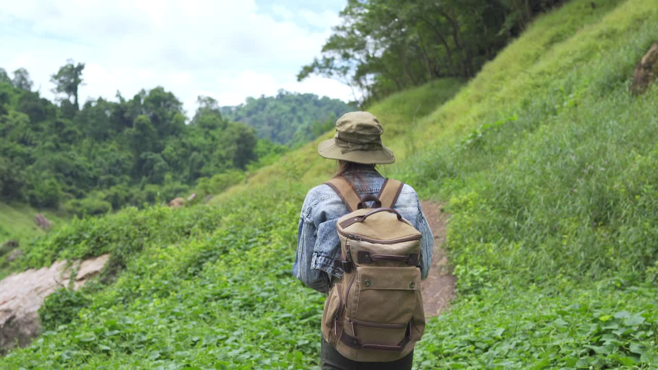 4K亚洲女性背包客在小溪边的山路上徒步旅行视频素材