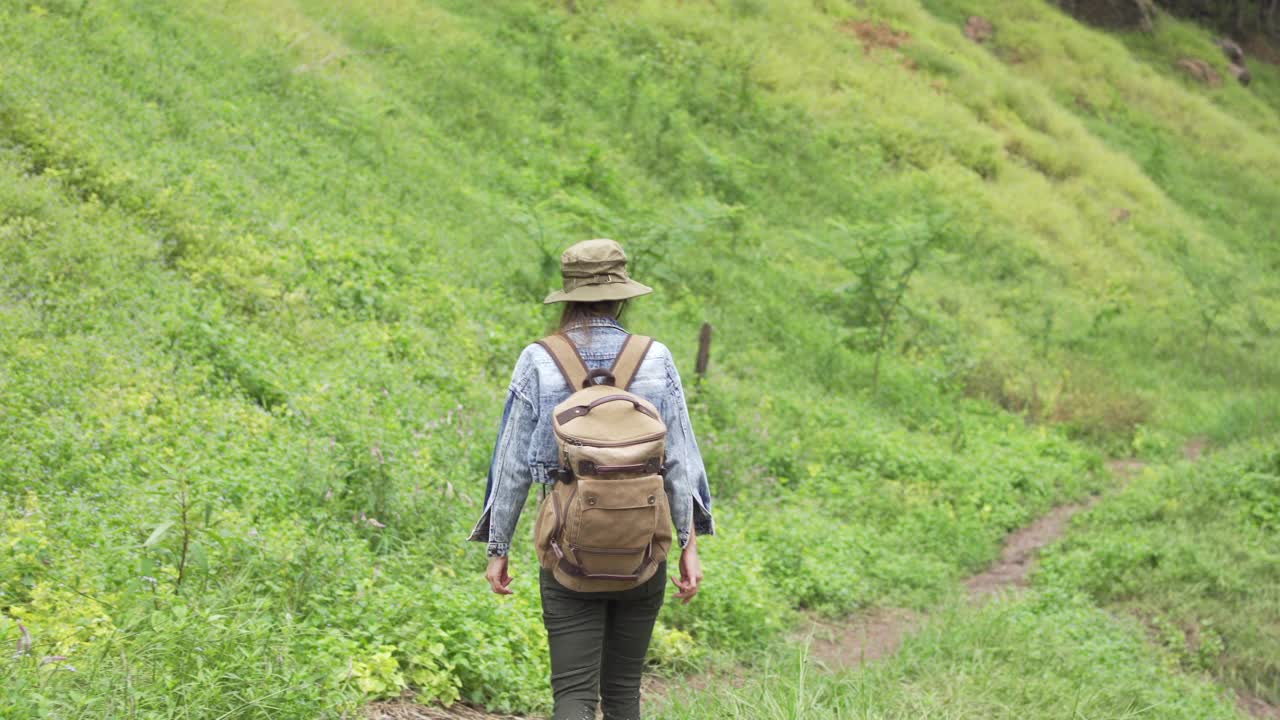 4K亚洲女性背包客在小溪边的山路上徒步旅行视频素材