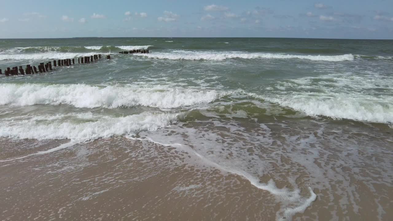 在一个阳光明媚的夏天，海浪和防波堤在海上视频素材