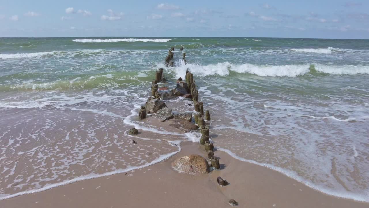 在一个阳光明媚的夏天，海浪和防波堤在海上视频素材