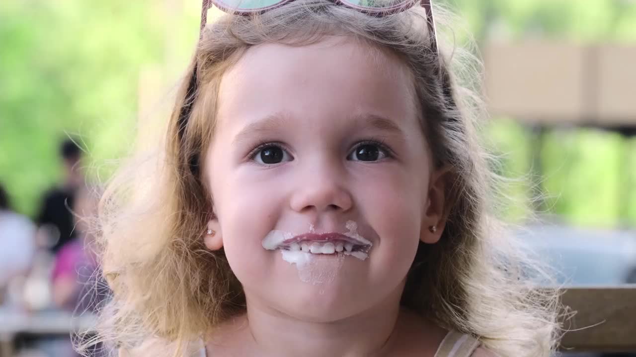 街上的咖啡馆附近，孩子们在吃蛋卷冰淇淋视频素材