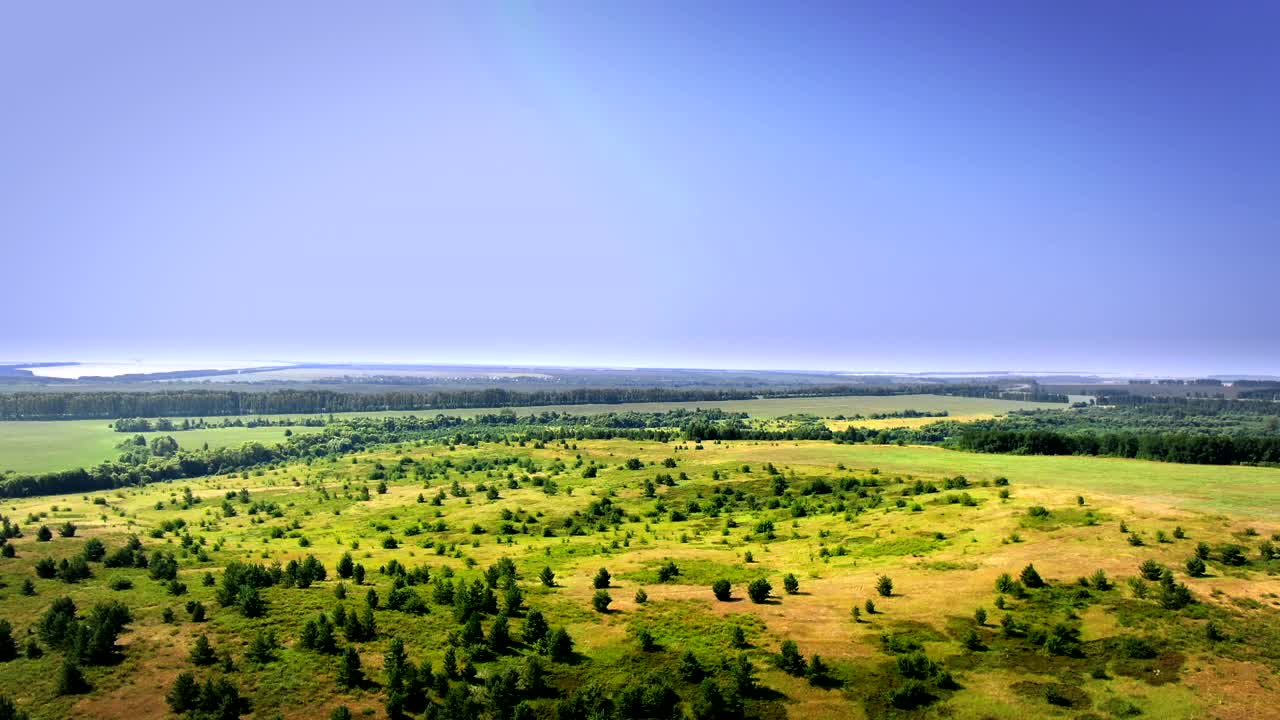 从鸟瞰图上可以看到森林和田野的惊人美景。在夏天，地球看起来很美丽，一切都是绿色的，一切都是盛开的。视频素材