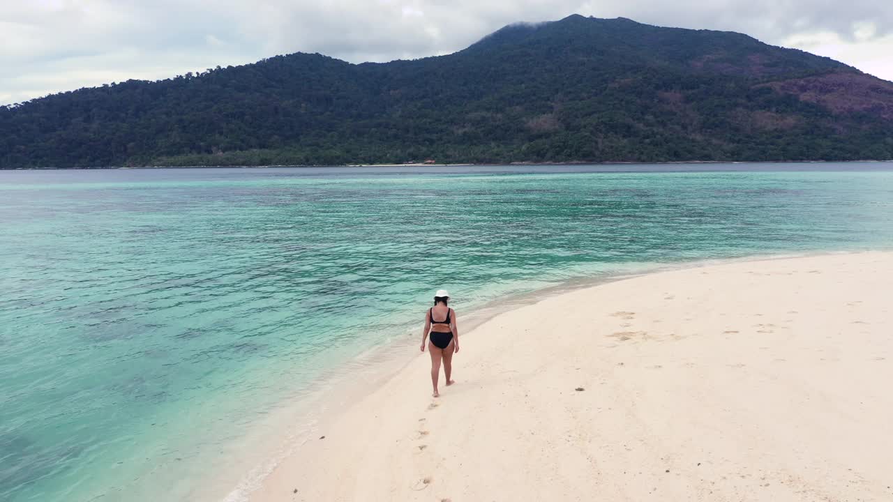 女人在海滩上散步视频素材