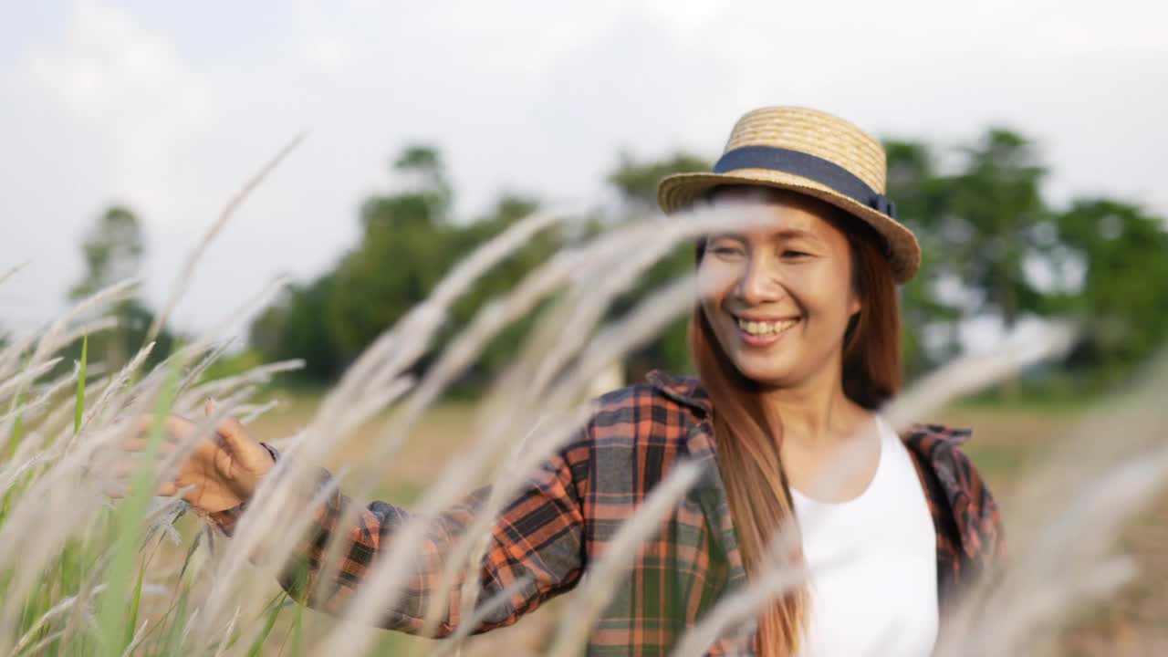 女性行走时触摸到绿叶视频素材