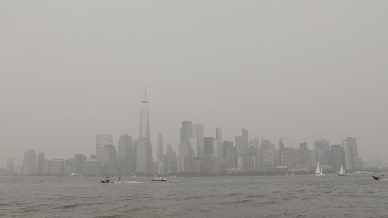 在浓重的雾霾中，纽约市中心的天际线与船只交通视频素材