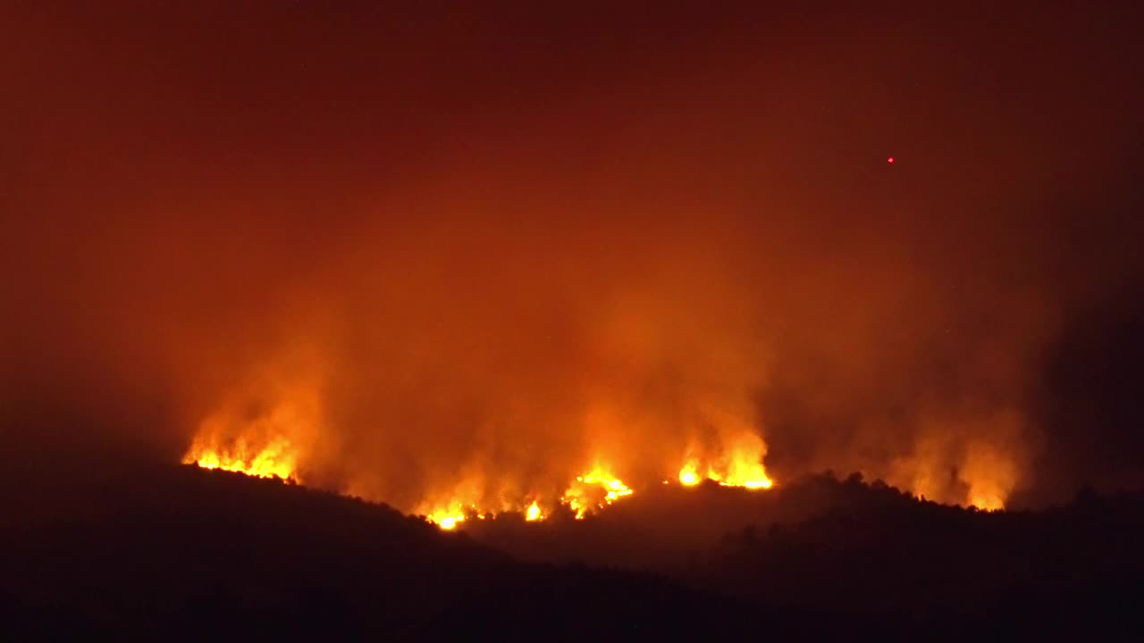 巨大的山林大火在夜间照亮了山景视频素材