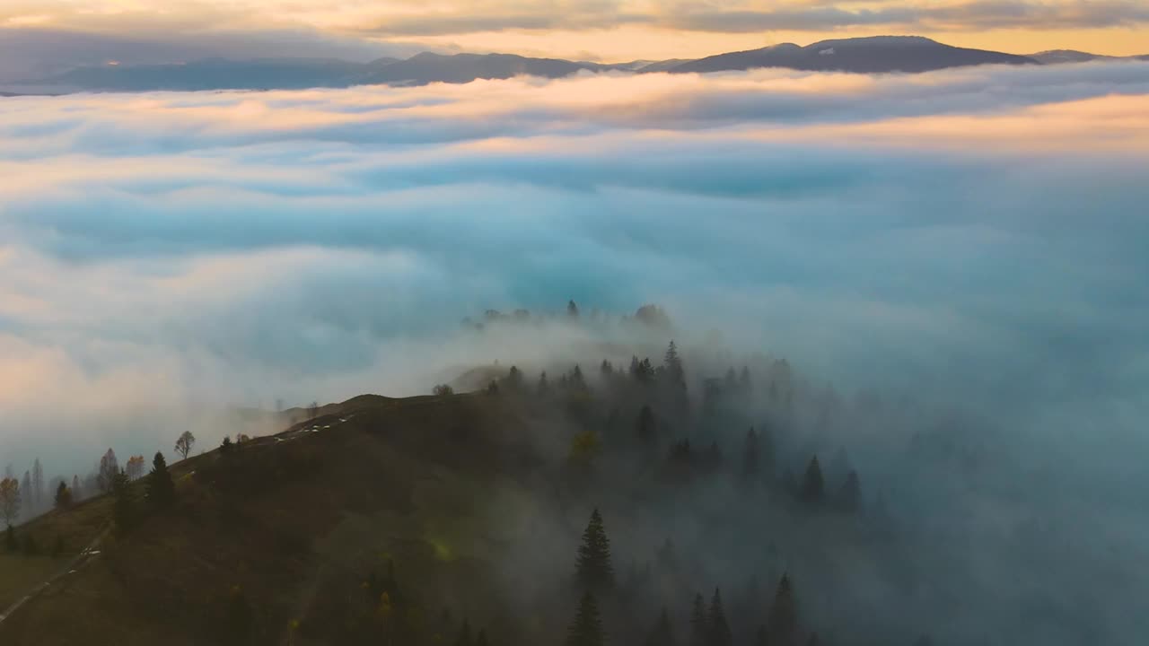 鸟瞰图的色彩丰富的景观，在雾蒙蒙的森林与松树覆盖的山在日落。视频素材