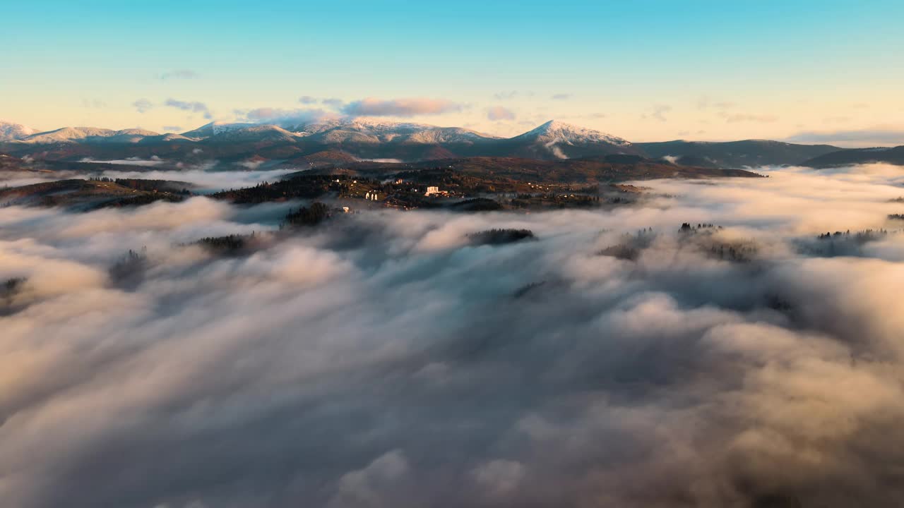 鸟瞰图的小村庄的房子在山顶在秋天雾山日出。视频素材