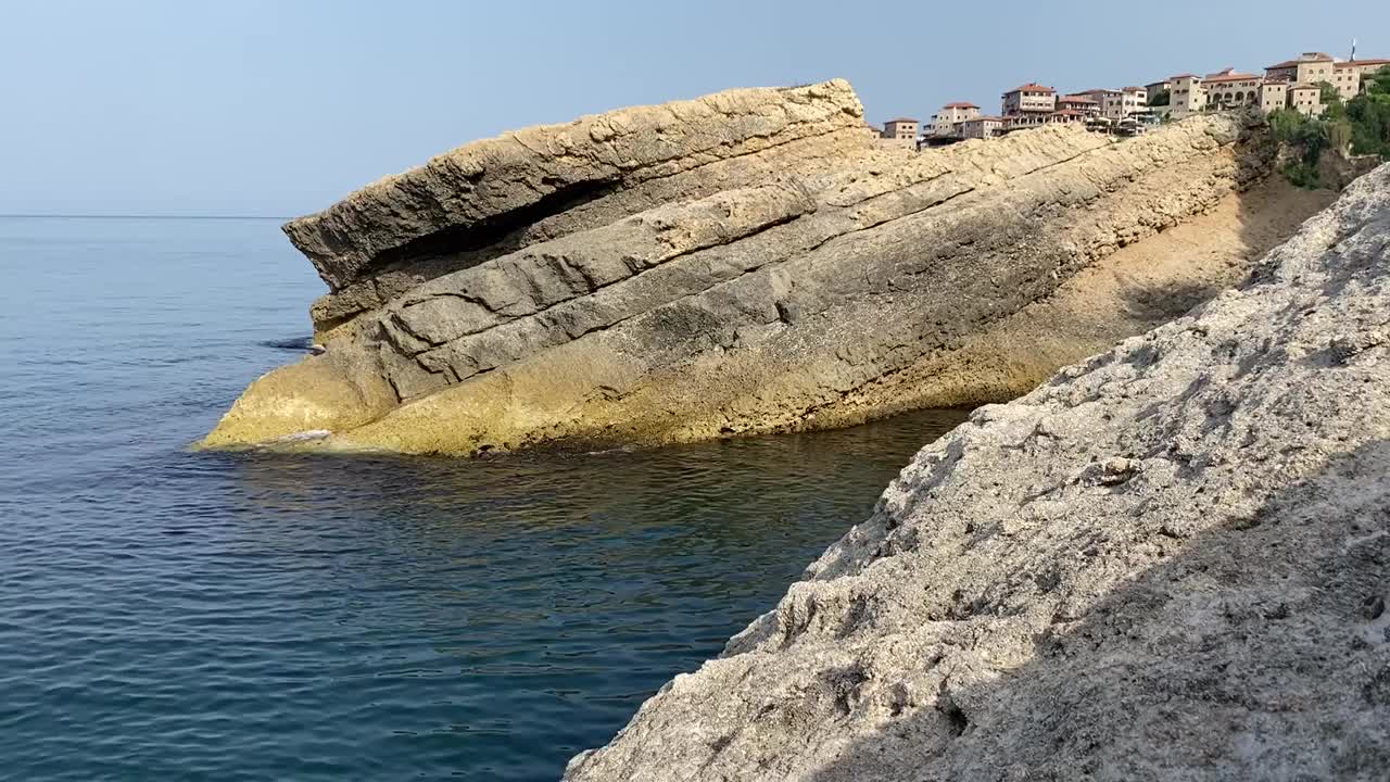 地中海岩石海岸。中世纪的古城在海岸悬崖和蓝色平静的海浪。古老的堡垒的观点。夏天。宁静。黑山。视频素材